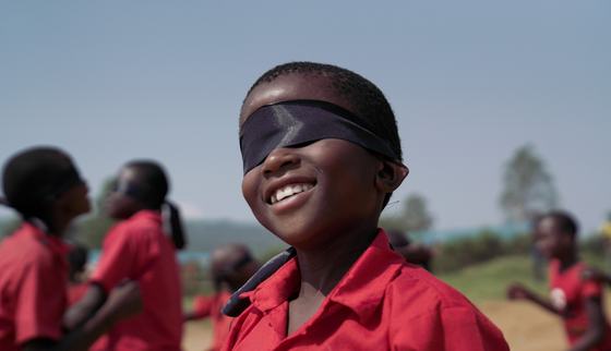Kindje met blinddoek spel tijdens TeamUp activiteiten_doorbreek het zwijgen_Oeganda_kind in oorlog_War Child 200301