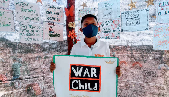 War Child in Colombia_boy with War Child logo and mask_21XXXX