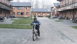 TeamUp jongen fietst over het terrein van azc asielzoekerscentrum Almere Stichting de Vrolijkheid_181206