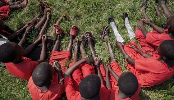 Meisjes in hun schooluniform in het gras in Oeganda_doorbreek het zwijgen_War Child Oeganda_200301