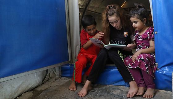 Nadia leest voor in de tent op een veilige plek in Mosul_War Child Irak_181004