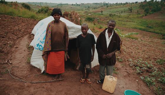 Roger in front of his house with his family_War Child Uganda_190918.jpg