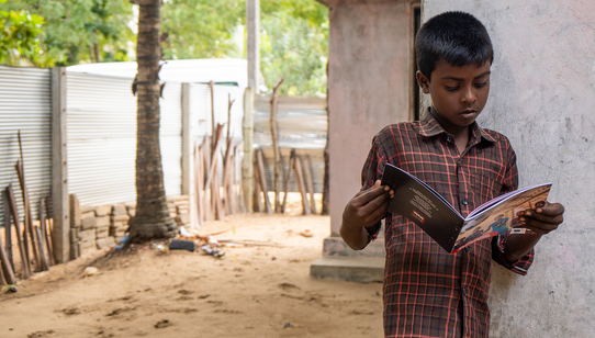War Child Holland_Mohan reading outside_Batticaloa_Sri Lanka_200223