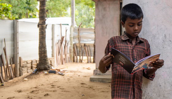 War Child Holland_Mohan reading outside_Batticaloa_Sri Lanka_200223