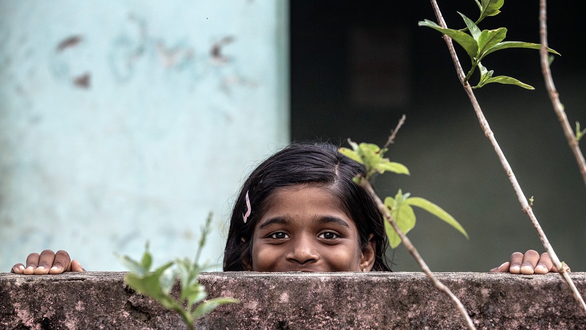 Sri Lanka meisje kijkt over een muur - War Child programma