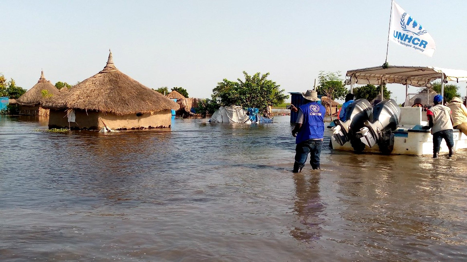 Team passing through flooded area of Tonga to the new temporary settlement; Tonga, Panyikang.