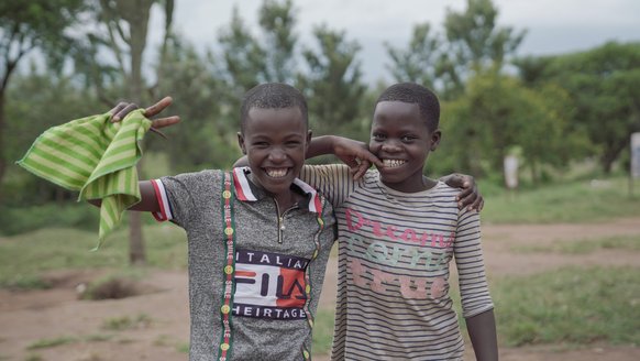 Lachend poseren Emilie en vriendin voor de camera, onder die lach trauma van oorlog - War Child doorbreek het zwijgen