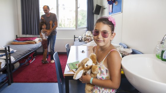 Meisje met haar knuffel in een azc in Sneek, Nederland