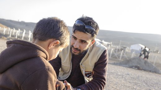 War Child staff talking to a child in Iraq