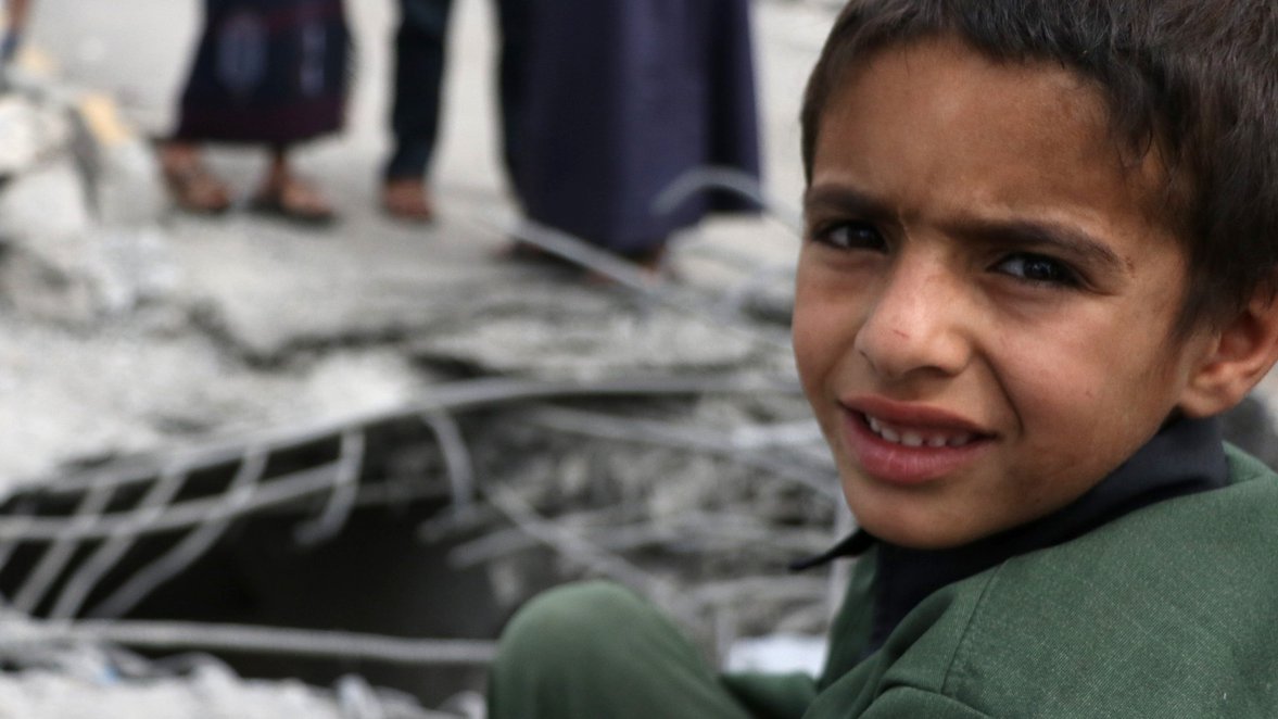 Child in a his destroyed neighborhood after an air strike in Yemen