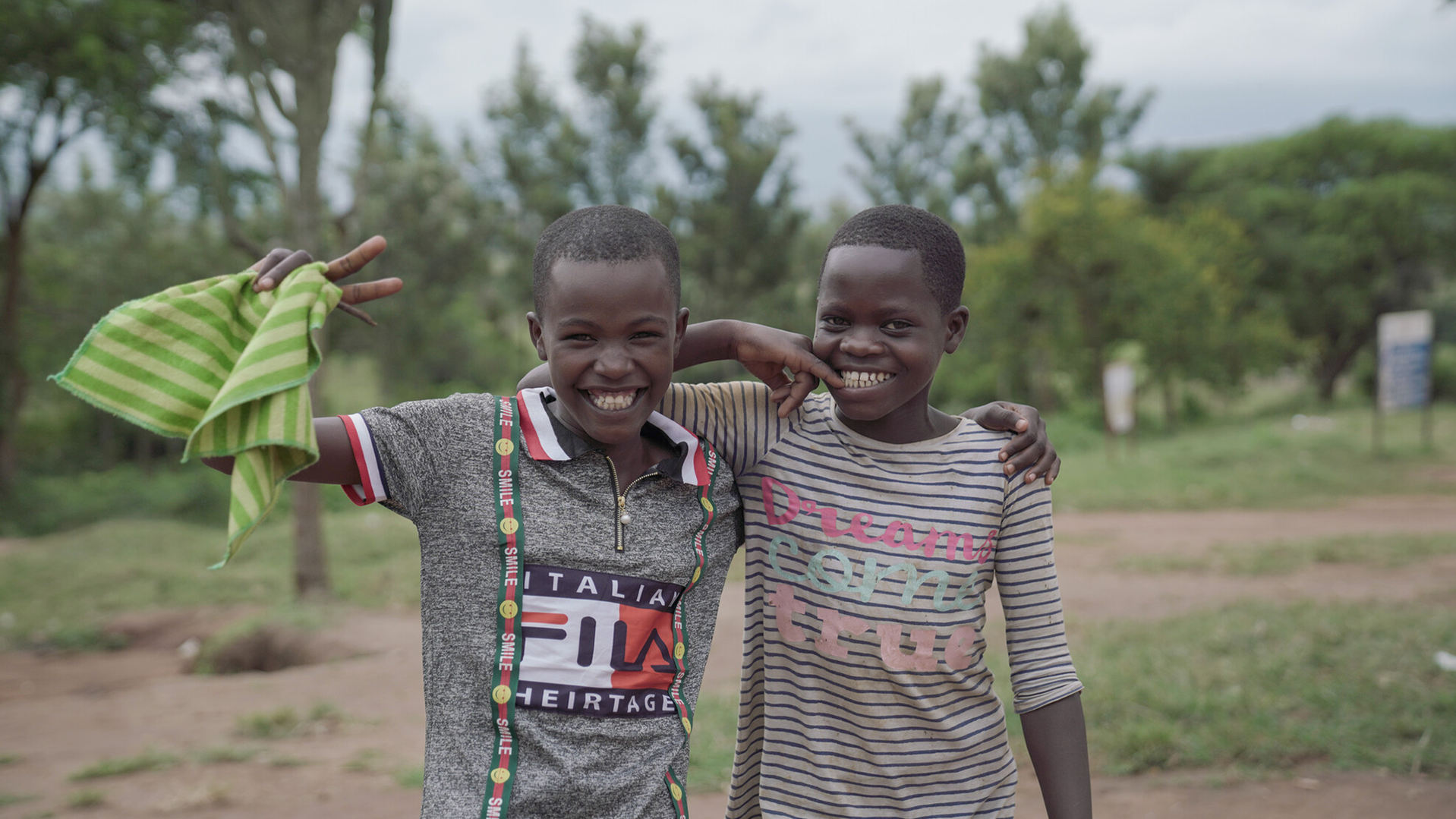 War Child in Oeganda - twee Oegandese kinderen kijkend lachend de camera in