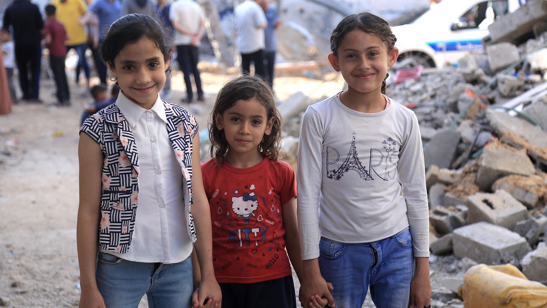 Three girls surrounded by destruction in Gaza following the bombings in May 2021