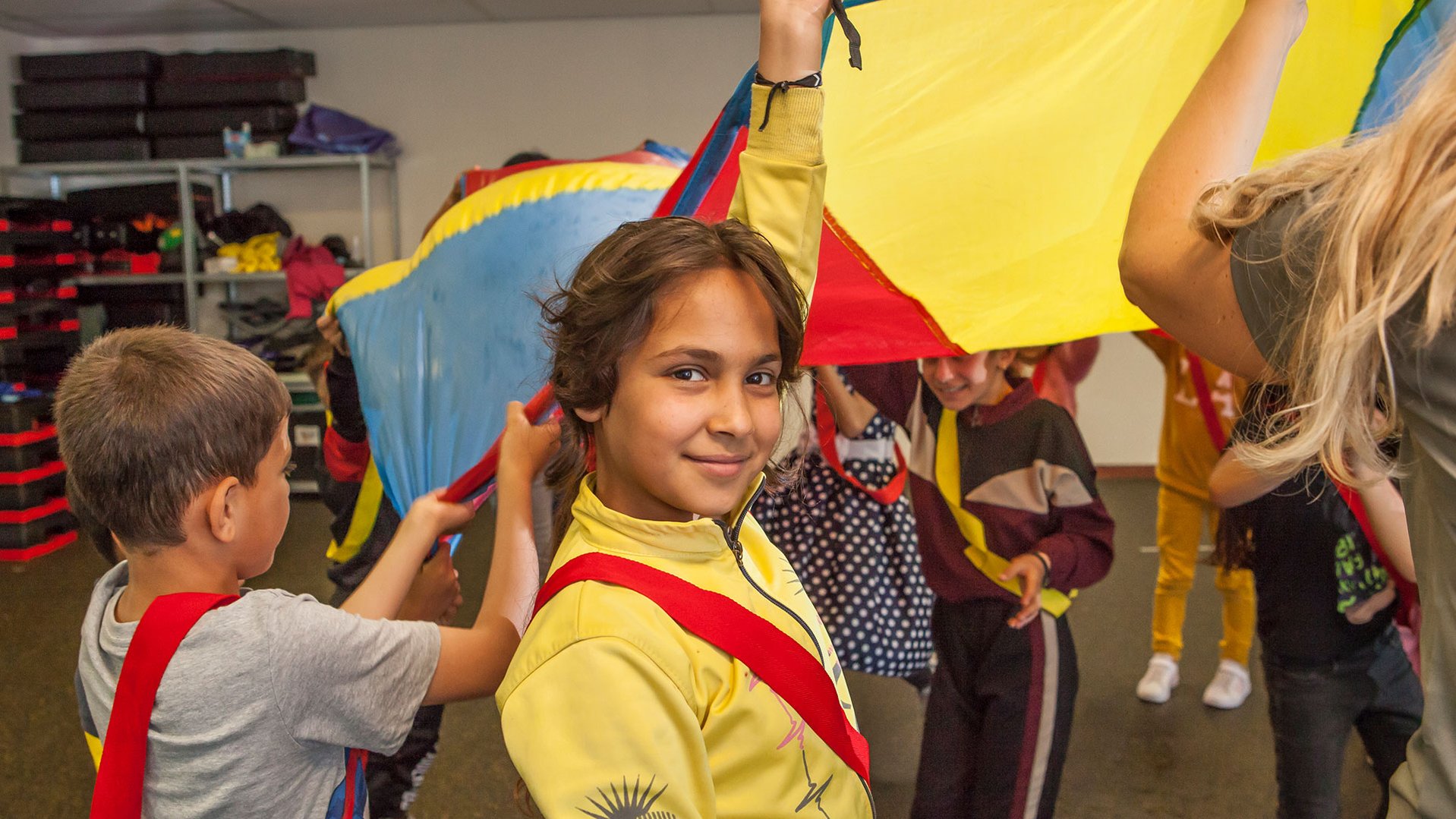 Girl looking at the camera smiling during a TeamUp session at a Dutch refugee center