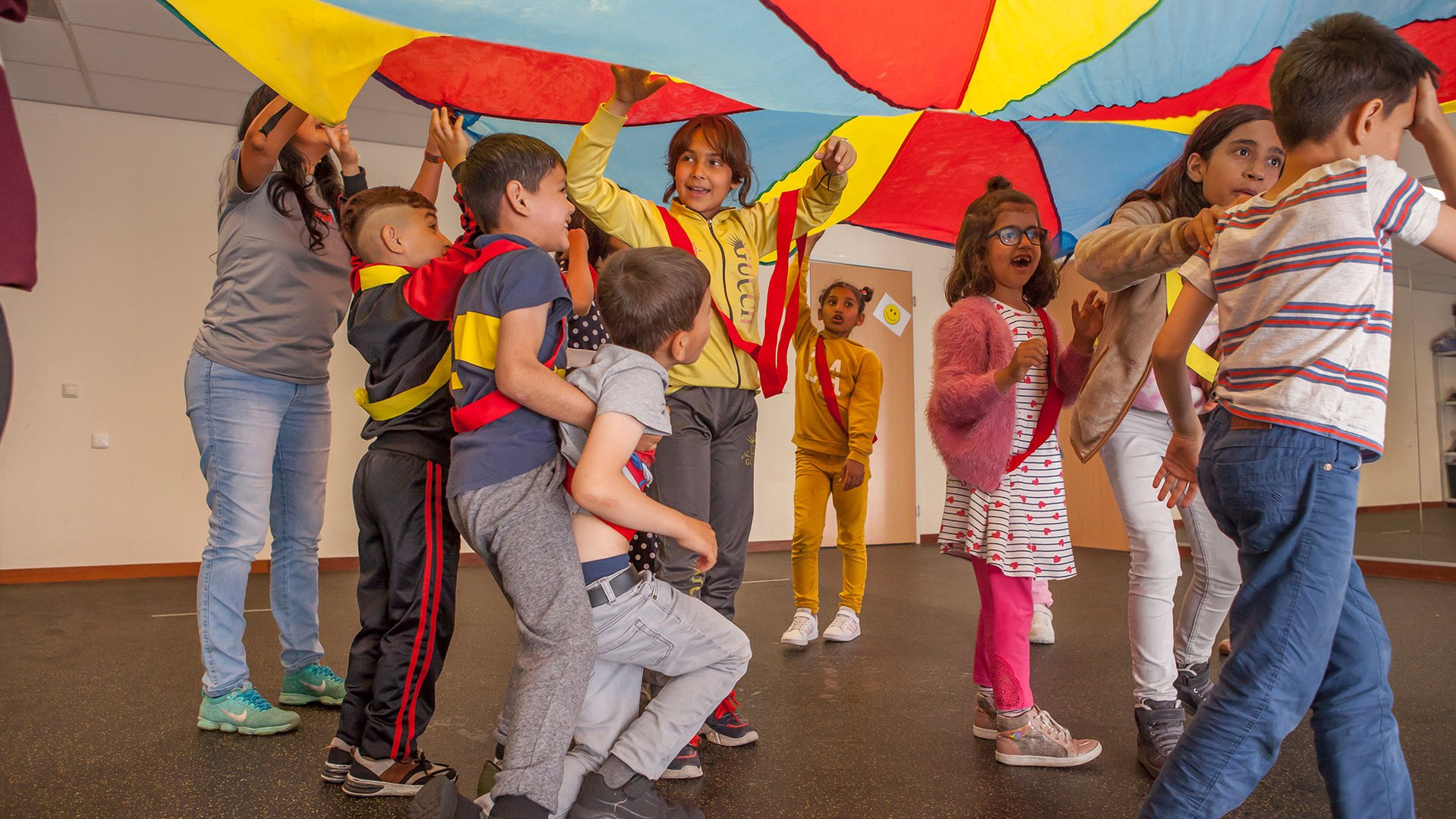 Refugee children playing with parachute during a TeamUp session at an asylum in the Netherlands