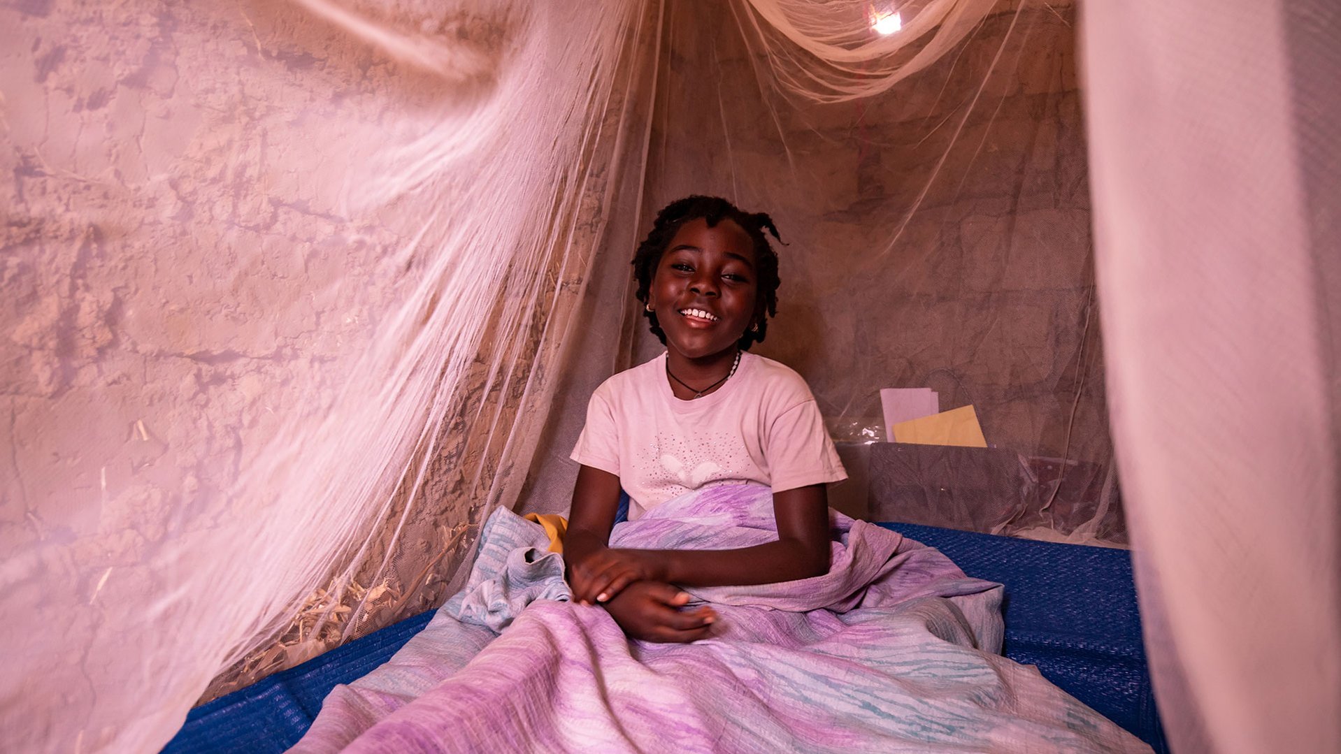 Congolese Mado (8) at her bed in an Ugandan refugee camp where she's joining our TeamUp and Can't Wait to Learn programmes