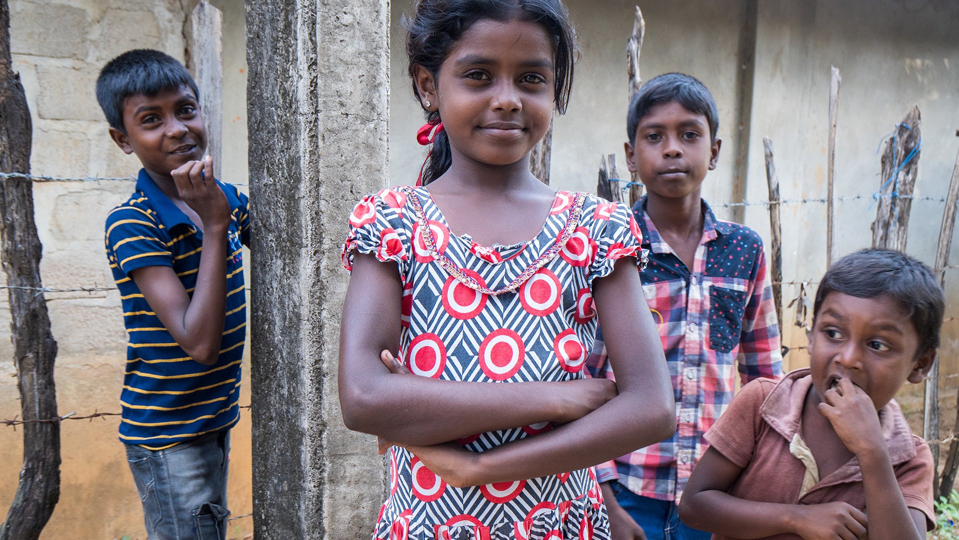 Meisje Sri Lanka met vrienden buiten voor een gebouw - War Child